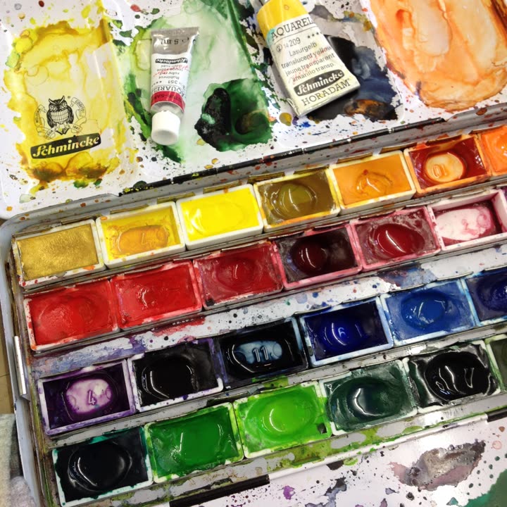 Gut benutzter Aquarellkasten mit bunten Farbnäpfen