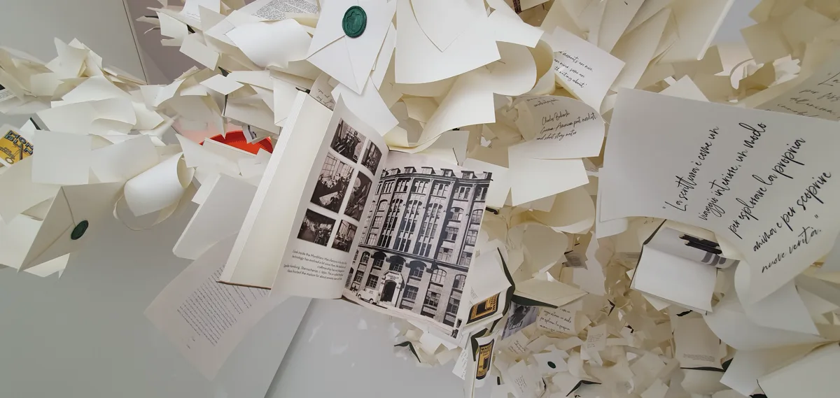 Aufgeschlagenes Buch mit historischen Schwarz-Weiß-Fotografien eines Kontorhauses, eingebettet ins Papiergeflecht, daneben handbeschriebene Zitatkarten.